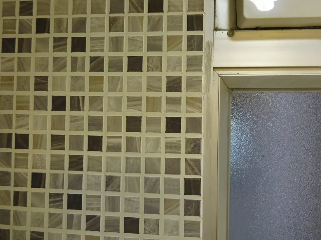 Geflieste Wand im Bad vor der Renovierung
