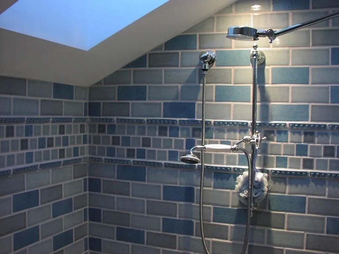 Geflieste Dusche mit Fugen und Armatur